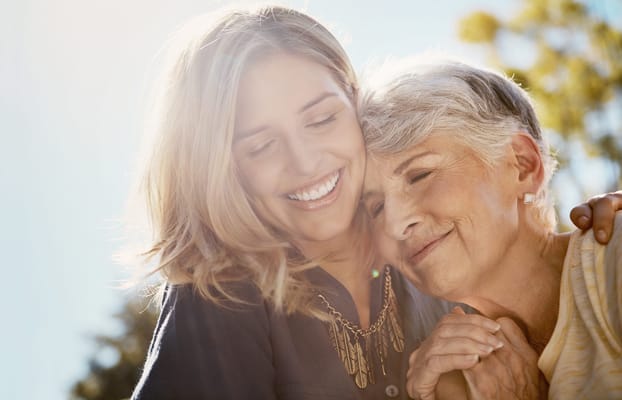Caregiver and resident sharing a joyful moment outdoors