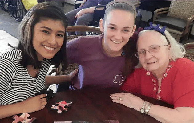 Residents engaged in a puzzle activity with volunteers