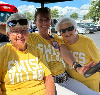 Three smiling residents in matching T-shirts