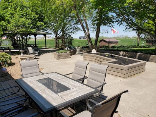 Outdoor seating area with tables and raised garden beds
