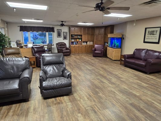A cozy common area with leather chairs and wood cabinets