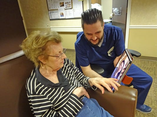 A caregiver and resident engaging with a tablet