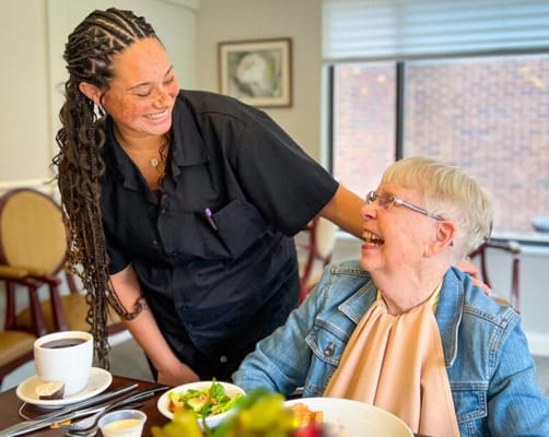 Staff interacting with a resident during meal time