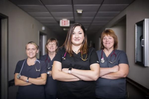 Four healthcare staff members posing in a hallway