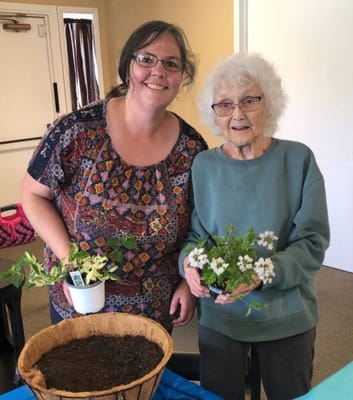 Resident and staff member planting flowers indoors