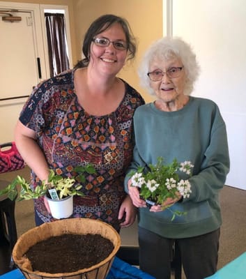 Resident and staff member planting flowers indoors
