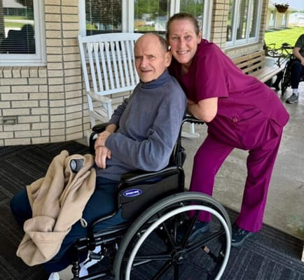 Resident and caregiver smiling in an outdoor space
