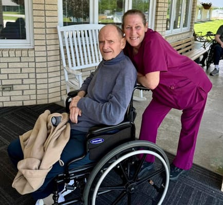 Resident and caregiver smiling in an outdoor space