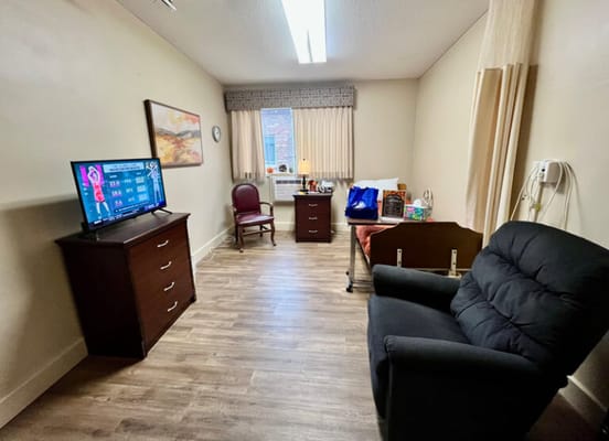 Private resident room with a TV and chair