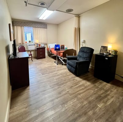 A private resident room with bed and seating