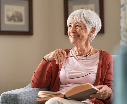 Senior woman reading a book in a cozy interior