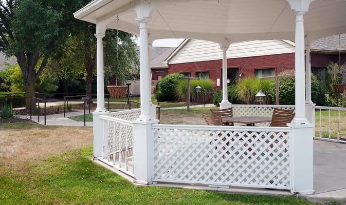 Outdoor gazebo with seating in a landscaped area