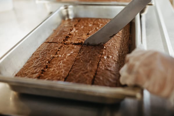 A tray of brownies being sliced in the kitchen