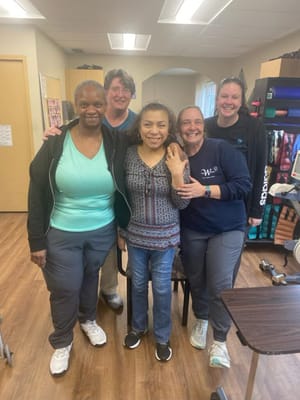 Staff and residents smiling together in a common area