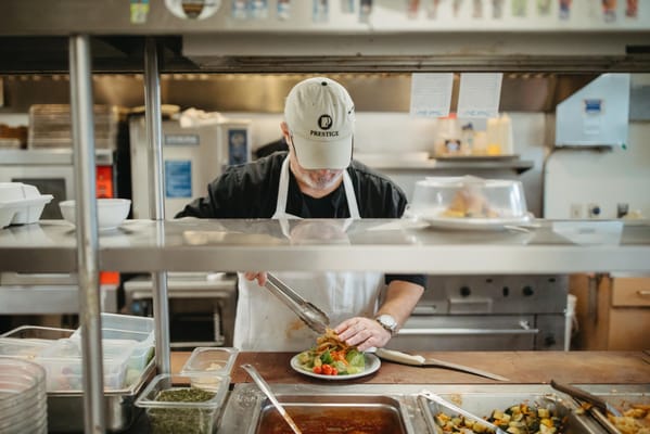 Staff member plating a meal in the kitchen