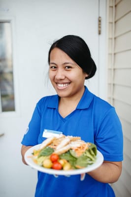Staff member presenting a beautifully plated meal