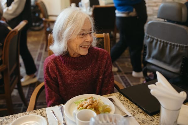 Resident enjoying a meal in the dining room