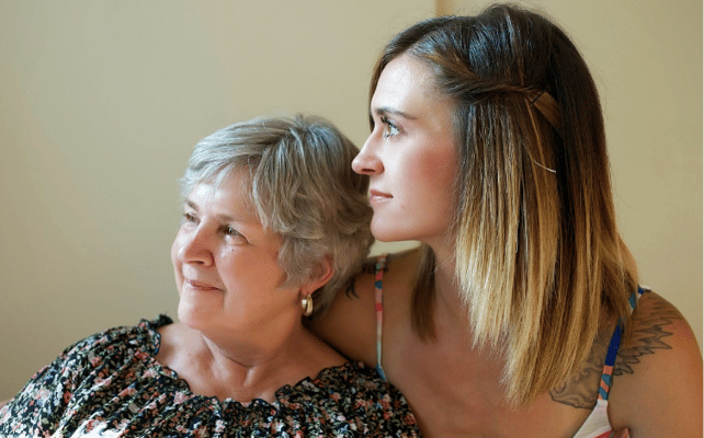Two women smiling together in a bright setting