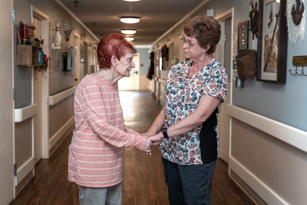 Staff member comforting a resident in a hallway