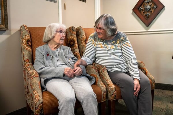 Two residents engaged in conversation in a cozy lounge area