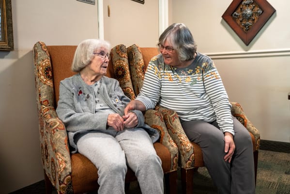 Two residents engaged in conversation in a cozy lounge area