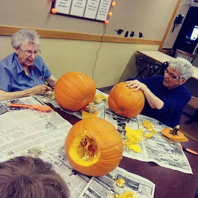 Residents carving pumpkins during an activity session