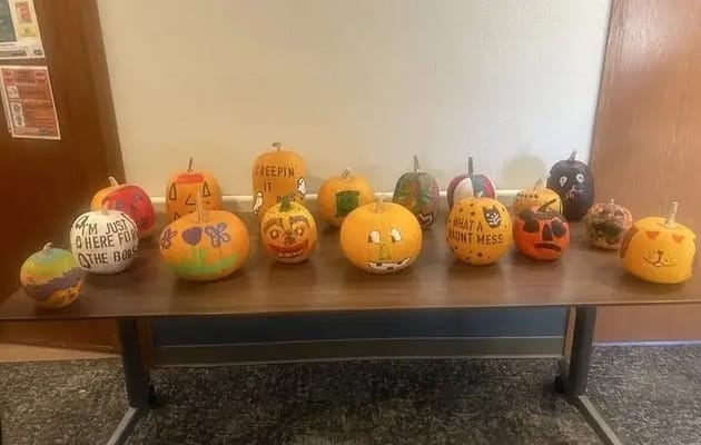 Decoratively painted pumpkins on a table in the common area