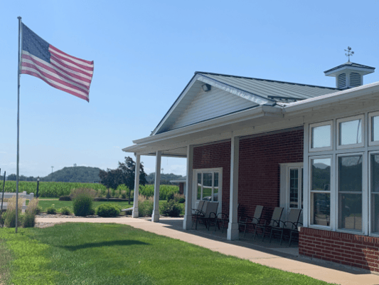 Exterior view of a nursing home facility with a flag