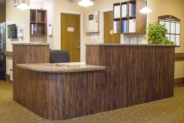 Reception area with a wooden counter and plants