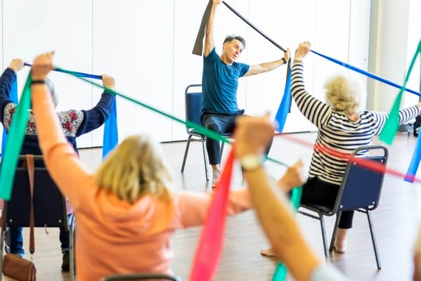 Residents participating in a seated exercise class with bands