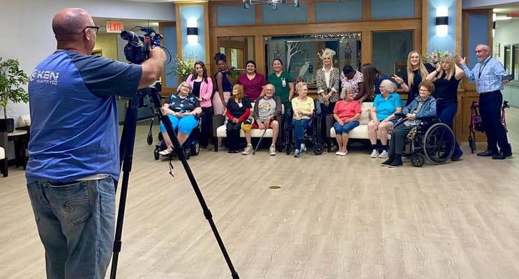Residents and staff posing for a group photo in a common area