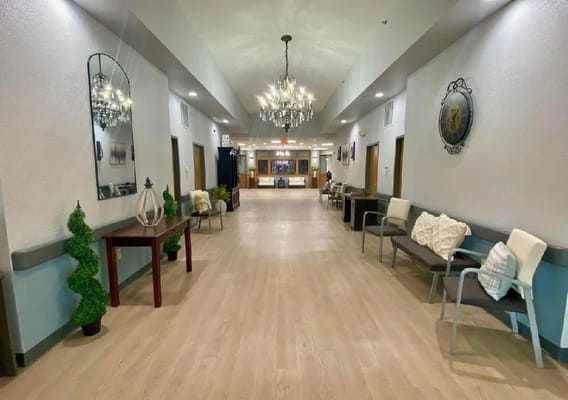 Bright interior hallway with seating and chandeliers