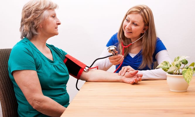 A healthcare worker taking a resident's blood pressure