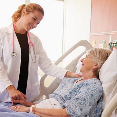A nurse caring for a senior resident in a hospital room