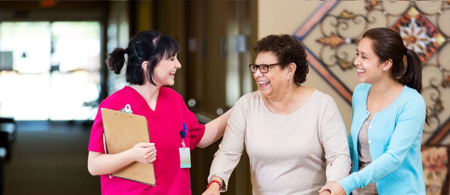 Care staff assisting a resident in a hallway