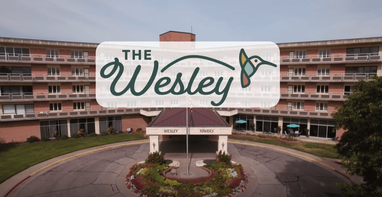 Entrance of The Wesley with gardens and logo