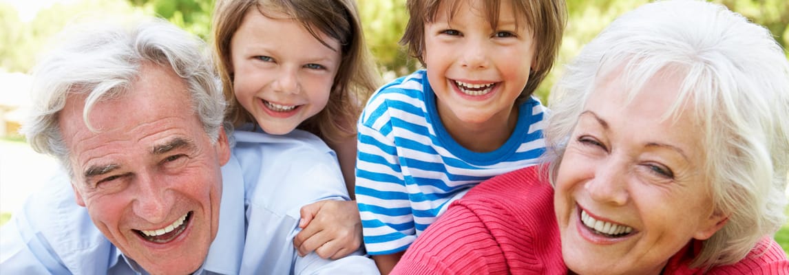 Smiling grandparents with grandchildren outdoors