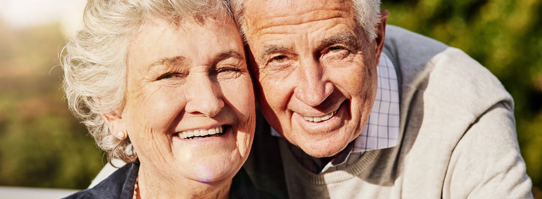 Elderly couple smiling together outdoors