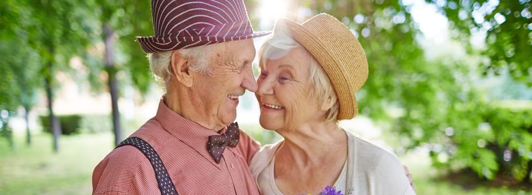 Elderly couple smiling together in a garden