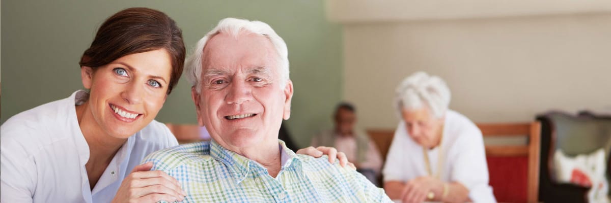 A caregiver smiling with a senior resident