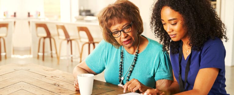 Resident and staff member engaged in an activity at a table