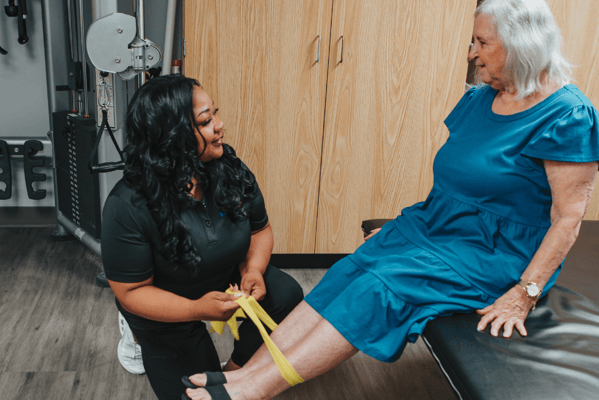 Therapist assisting a senior in a treatment room