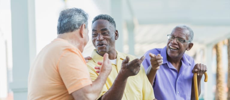 Three men engaged in a cheerful conversation