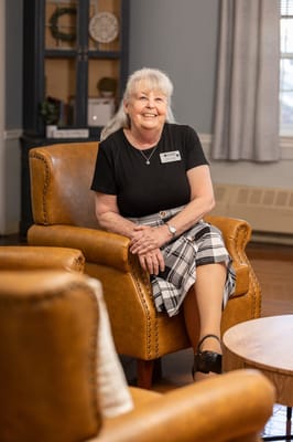 Staff member smiling in a cozy sitting area