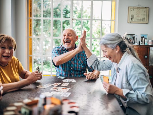 Seniors enjoying a lively card game indoors