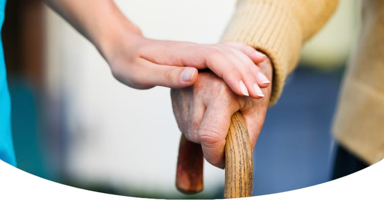 Close-up of a caregiver's hand on a senior's hand