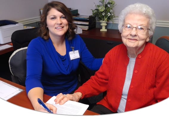 Staff member assisting a resident at a desk