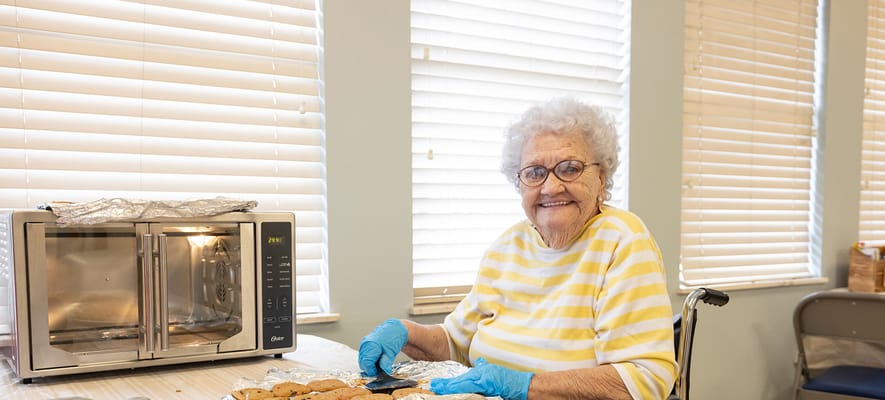Resident baking cookies in a sunny kitchen
