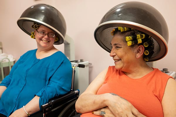 Residents enjoying hairstyling treatments in a salon area