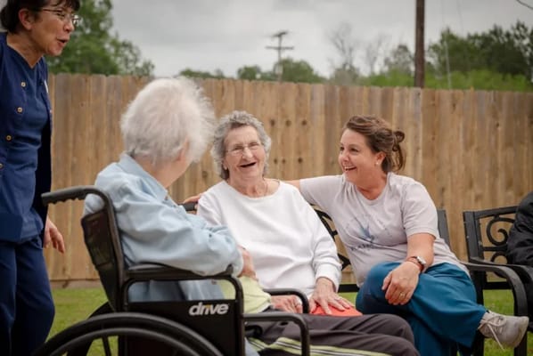 Residents enjoying outdoor conversation with staff